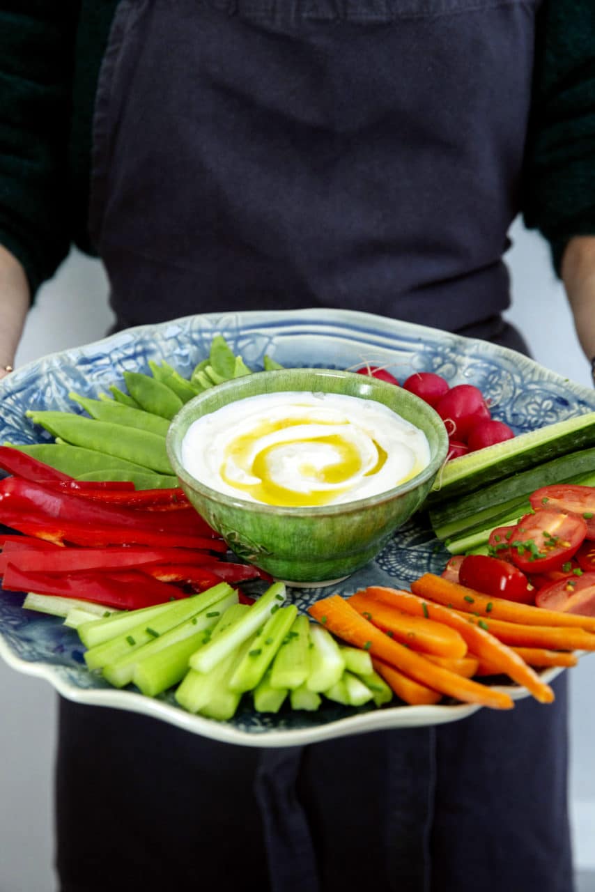 bild på typisk medelhavskosten, dippa med olika grönsaker på ett fat.