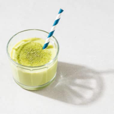 Glas med grön smoothie gjord på yoghurt toppad med matcha.