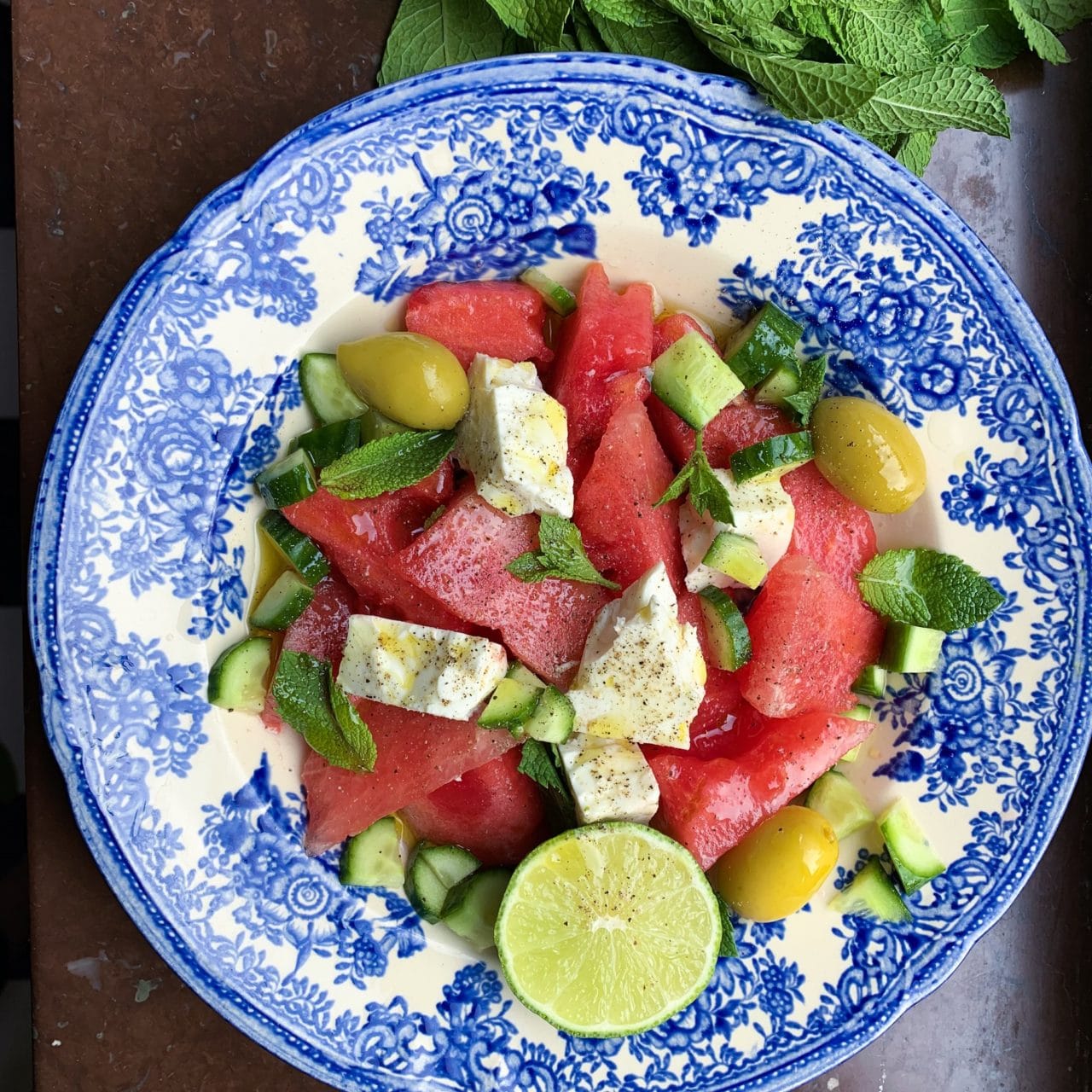 Blå och vit tallrik med vattenmelon, oliver, gurka och Larsa Feta