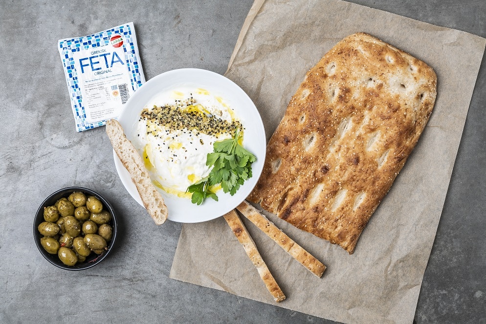 Bröd och en skål med feta dipp och oliver