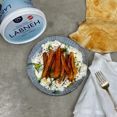 En tallrik med Labneh toppad med ugnsrostade morötter dekorerade med chiliflakes och dill.